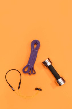 Masaj merdiveni spor emniyet kemeri turuncu arka planda elma ve havlu.