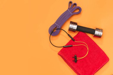 Masaj merdiveni spor emniyet kemeri turuncu arka planda elma ve havlu.