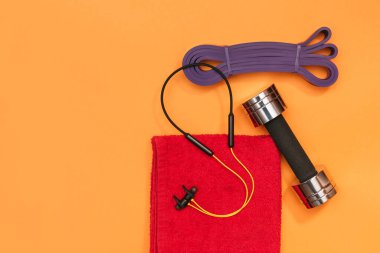 Masaj merdiveni spor emniyet kemeri turuncu arka planda elma ve havlu.