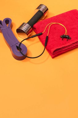 Masaj merdiveni spor emniyet kemeri turuncu arka planda elma ve havlu.