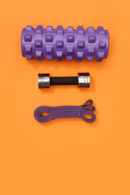 Masaj merdiveni spor emniyet kemeri turuncu arka planda elma ve havlu.