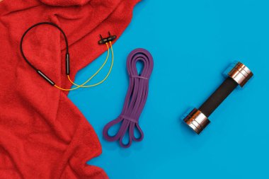 Masaj merdiveni spor tasması mavi arka planda elma ve havlu.