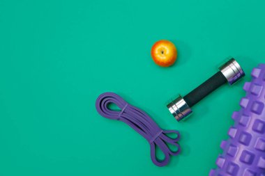 Masaj merdiveni spor tasması yeşil arka planda elma ve havlu