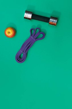 Masaj merdiveni spor tasması yeşil arka planda elma ve havlu