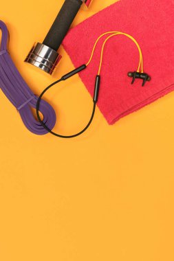 Sarı arka planda masaj merdiveni spor emniyet kemeri elma ve havlu.