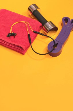 Sarı arka planda masaj merdiveni spor emniyet kemeri elma ve havlu.
