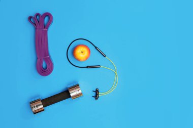 Masaj merdiveni spor tasması mavi arka planda elma ve havlu.