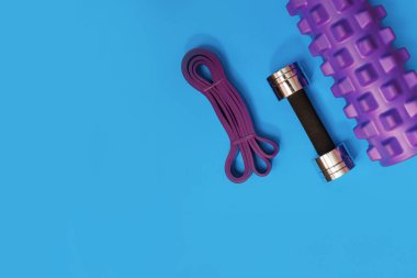 Masaj merdiveni spor tasması mavi arka planda elma ve havlu.