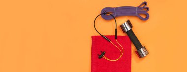 Masaj merdiveni spor emniyet kemeri turuncu arka plan panoramasında elma ve havlu