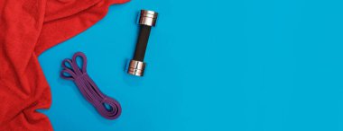 Masaj merdiveni spor tasması mavi arka plan panoramasında elma ve havlu.