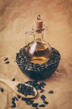 Bir torba tohumla ve tahta kaşıkla ayçiçeği yağı.