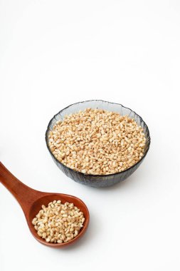 Tahta kaşıkta ve tabakta çiğ inci arpası.