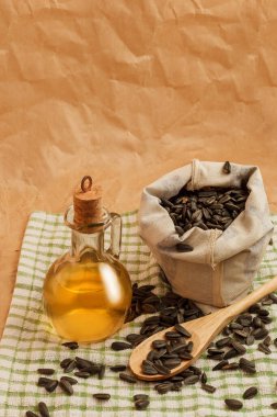 Bir torba tohumla ve tahta kaşıkla ayçiçeği yağı.