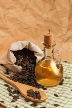 Bir torba tohumla ve tahta kaşıkla ayçiçeği yağı.