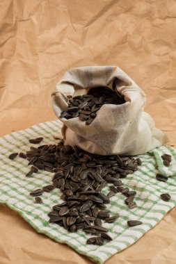 Kağıt zemin üzerinde ayçiçeği tohumları olan bir kese.