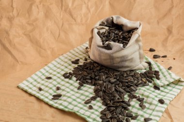 Kağıt zemin üzerinde ayçiçeği tohumları olan bir kese.