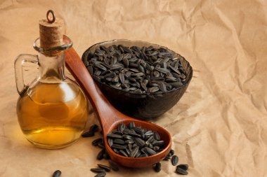Bir torba tohumla ve tahta kaşıkla ayçiçeği yağı.