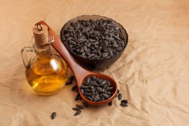 Bir torba tohumla ve tahta kaşıkla ayçiçeği yağı.