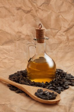 Bir torba tohumla ve tahta kaşıkla ayçiçeği yağı.