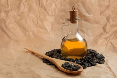 Bir torba tohumla ve tahta kaşıkla ayçiçeği yağı.