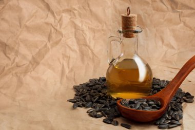 Bir torba tohumla ve tahta kaşıkla ayçiçeği yağı.