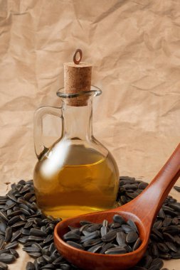 Bir torba tohumla ve tahta kaşıkla ayçiçeği yağı.