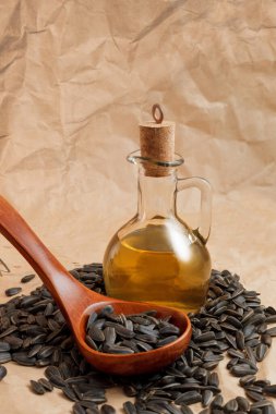 Bir torba tohumla ve tahta kaşıkla ayçiçeği yağı.