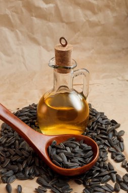 Bir torba tohumla ve tahta kaşıkla ayçiçeği yağı.