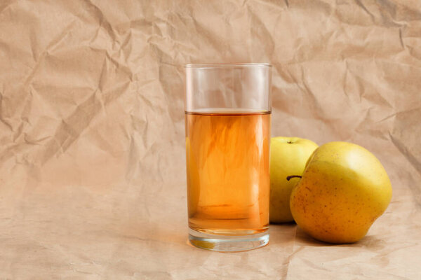 a glass of apple juice with apples