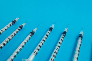 Mavi arka planda tıbbi şırıngalar