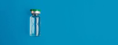 Mavi panorama arka planında ilaç içeren ampul