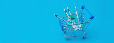 Mavi panorama arka planında şırınga ve ampul bulunan süpermarket tramvayı