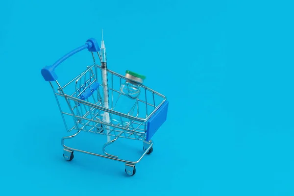 Carrito Supermercado Con Jeringas Ampolla Sobre Fondo Azul —  Fotos de Stock