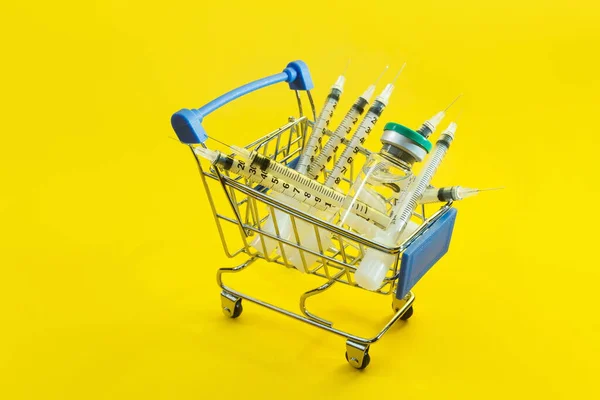 Тележка Супермаркета Шприцами Ампулами Желтом Фоне — стоковое фото