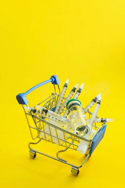 Supermarkttrolley Met Spuiten Ampul Gele Achtergrond — Stockfoto