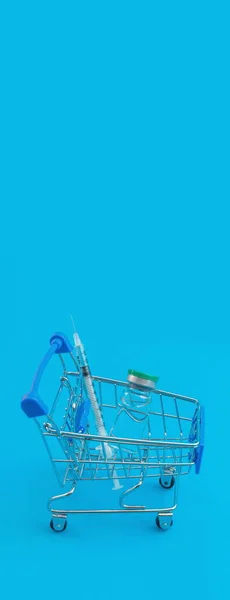 带有注射器和蓝色全景衬托的超级市场推车 — 图库照片
