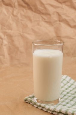 Buruşmuş kağıdın üzerinde bir bardak süt.