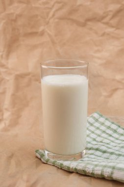 Buruşmuş kağıdın üzerinde bir bardak süt.