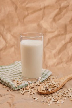 Bir bardak süt ve yulaf ezmeli ahşap kaşık.