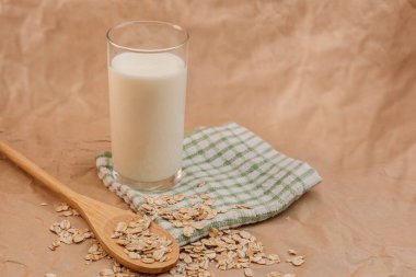 Bir bardak süt ve yulaf ezmeli ahşap kaşık.