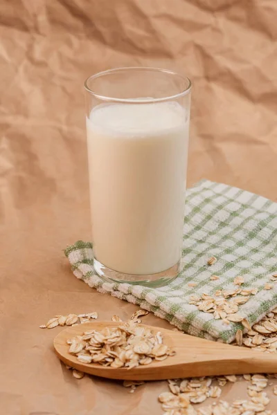 ミルクと木のスプーンのガラスにオートミール — ストック写真