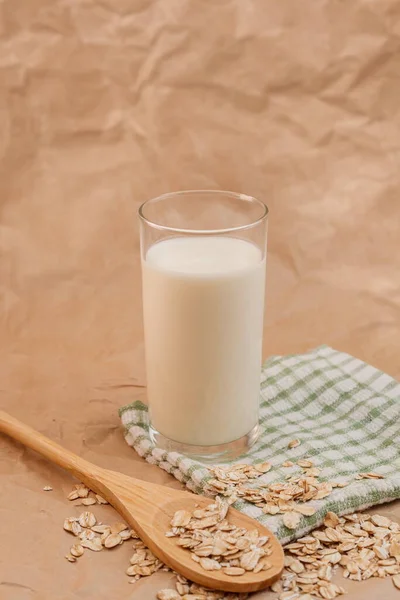 Glas Mjölk Och Trä Sked Med Havregryn Skrynkligt Papper Bakgrund — Stockfoto
