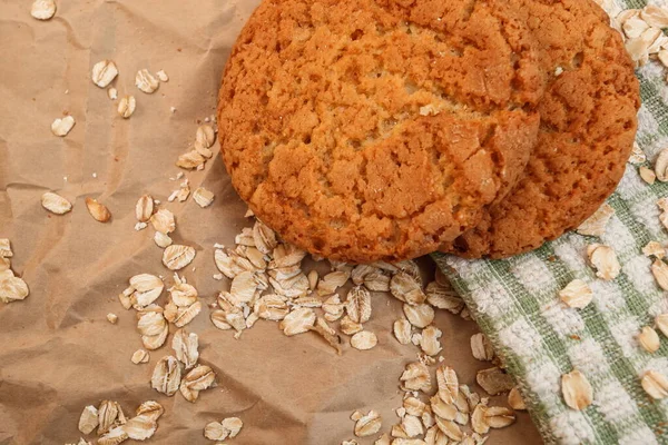 oatmeal cookies and scattered oatmeal on crumpled paper background