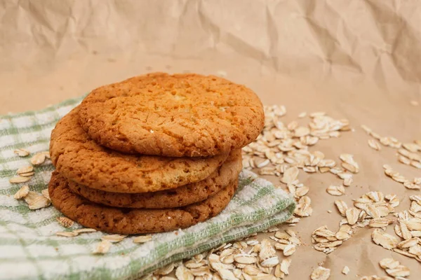 oatmeal cookies and scattered oatmeal on crumpled paper background