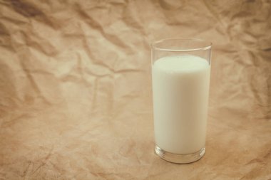 Buruşmuş kağıdın üzerinde bir bardak süt.