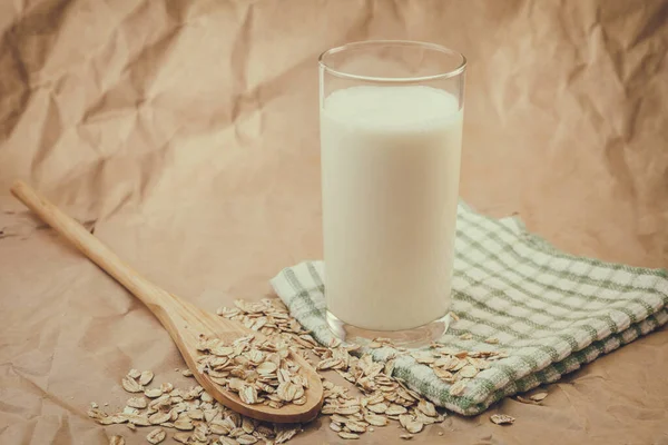 ミルクと木のスプーンのガラスにオートミール — ストック写真