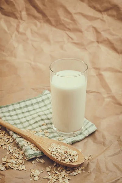Glas Mjölk Och Trä Sked Med Havregryn Skrynkligt Papper Bakgrund — Stockfoto