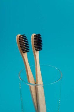 Bardaktaki mavi arka planda ahşap diş fırçası