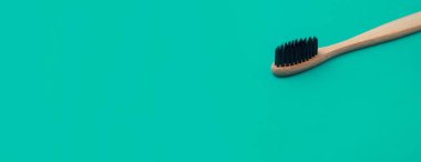 Yeşil panoramik zemin üzerinde ahşap diş fırçası