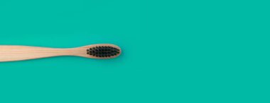 Yeşil panoramik zemin üzerinde ahşap diş fırçası